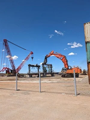 Offshore oil platform being taken apart by heavy machinery.