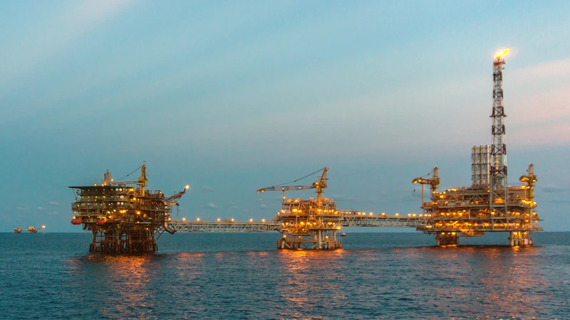 An offshore oil and gas platform light up at night.