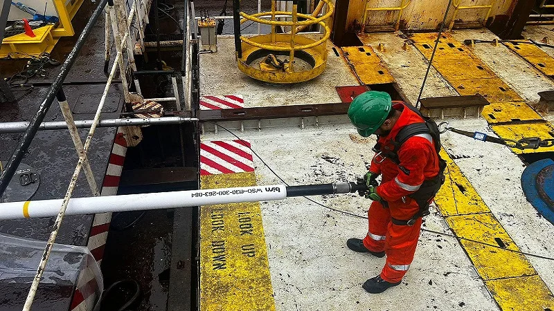 An offshore oil rig worker tending to the BiSN wel-lok technology at deployment