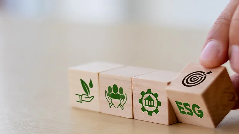 Building blocks being stacked one after the other with green, environmental symbols on them.