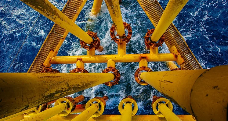 An overhead shot of offshore oil platform supports as they enter the sea.