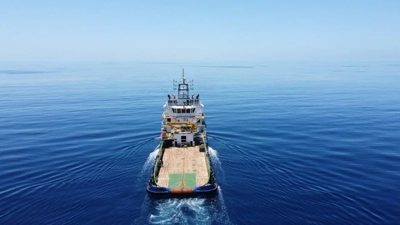 A behind show of a marine vessel setting sail into the open ocean