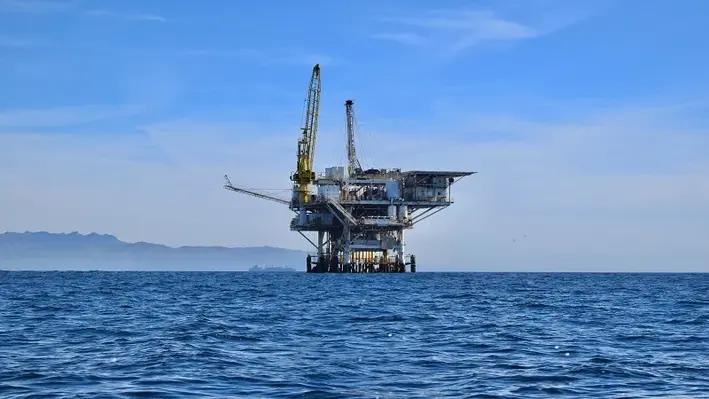 An offshore oil and gas platform on the horizon. 