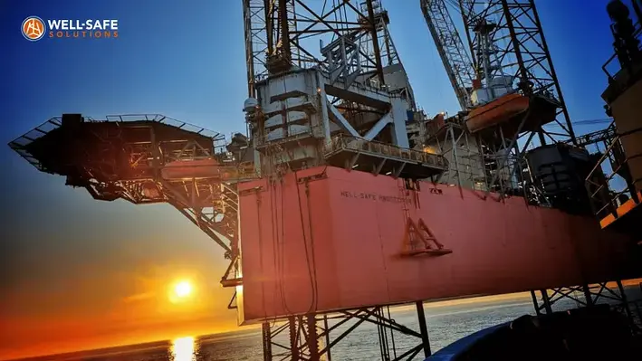 Image of Well-Safe Protector jack-up rig with the sun setting behind