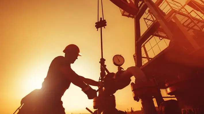 Sillhouette_of_a_worker_repairing_drill_pipe_as_part_of_workover 