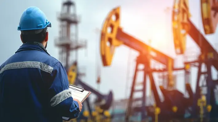 Engineer-blue-overalls-desert-oil-field-pumpjack