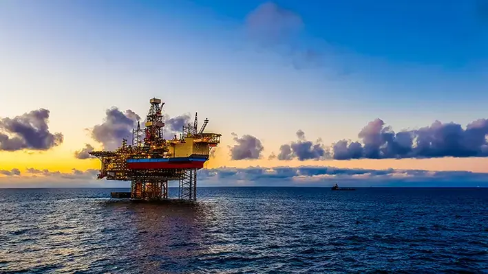 Image of an offshore oil rig at sunset 