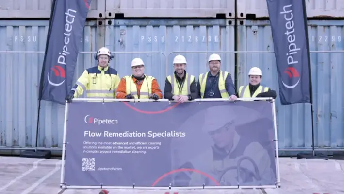 Lineup_of_five_people_in_hard_hats_with_Pipetech_banner